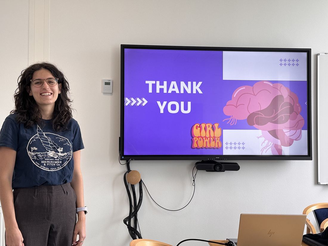 Miriam Fiorino smiling next to her 'Thank you' slide after presenting at journal club.